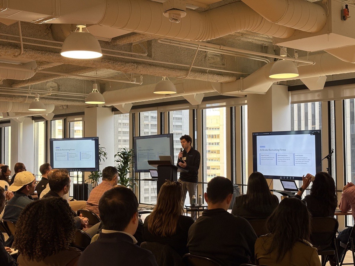 Seth Tilliss speaking at a podium in front of screens reading "AI Broke Recruiting Firms"